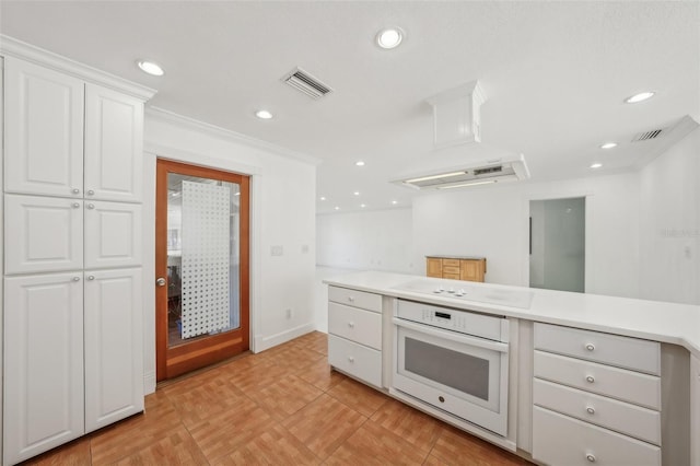 kitchen featuring recessed lighting, white appliances, visible vents, white cabinetry, and light countertops