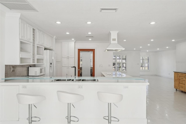 kitchen featuring light countertops, white appliances, white cabinets, and a kitchen breakfast bar