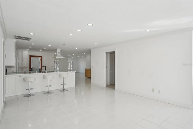 interior space featuring recessed lighting, visible vents, a sink, and baseboards