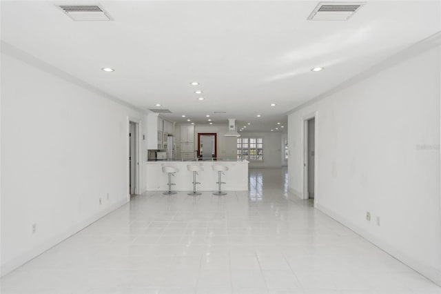 unfurnished living room with visible vents and recessed lighting