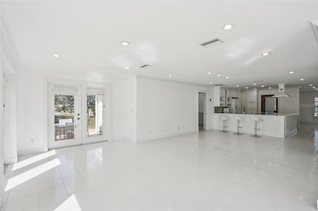 unfurnished living room with light tile patterned floors, french doors, visible vents, and recessed lighting