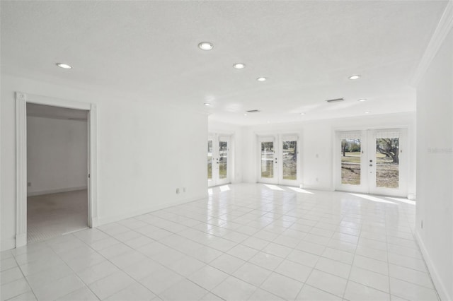 unfurnished living room with light tile patterned floors, french doors, a wealth of natural light, and recessed lighting