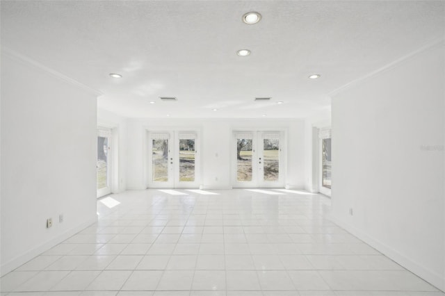 empty room featuring light tile patterned floors, visible vents, ornamental molding, and french doors