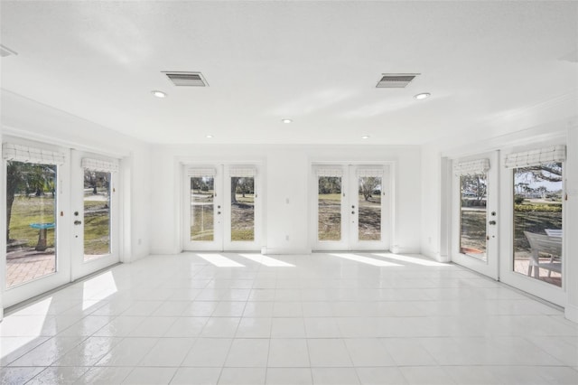 unfurnished sunroom featuring a wealth of natural light, french doors, and visible vents