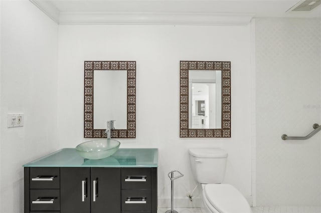 bathroom featuring toilet, vanity, visible vents, baseboards, and crown molding