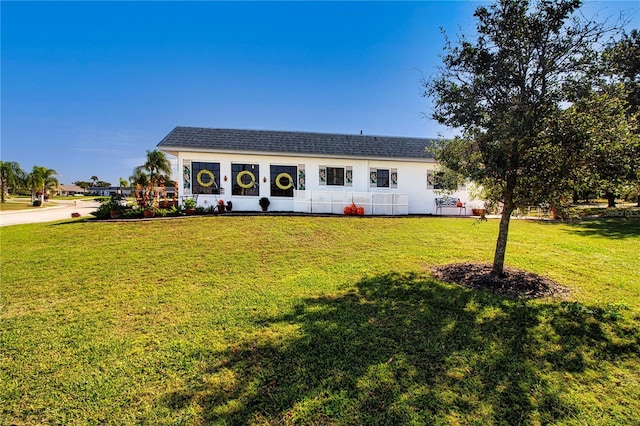 view of front of home featuring a front lawn and roof with shingles