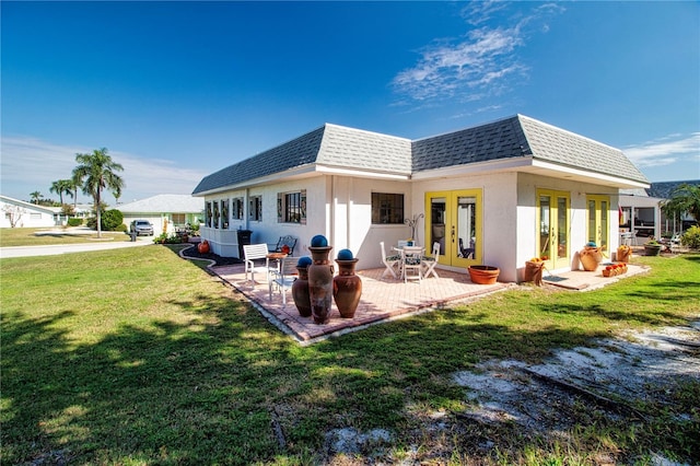 rear view of property featuring roof with shingles, french doors, mansard roof, and a patio