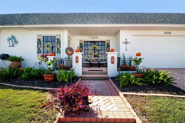 property entrance with a shingled roof, a porch, and brick siding