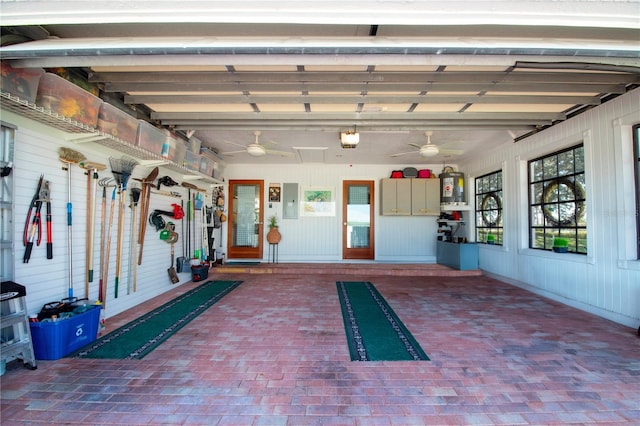 garage featuring a garage door opener, a ceiling fan, and electric panel