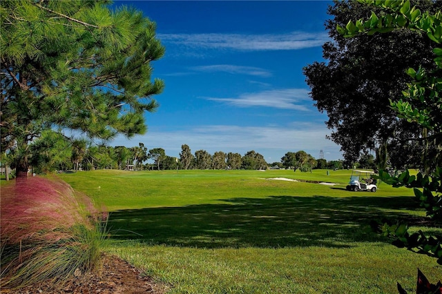 surrounding community with a yard and golf course view