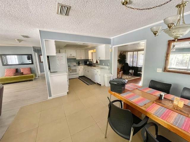 dining space featuring ornamental molding, sink, a textured ceiling, and light tile patterned floors