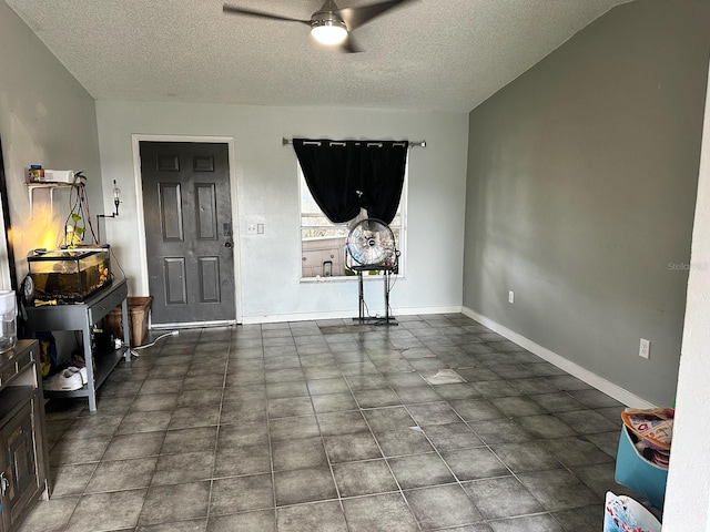 tiled living room with ceiling fan and a textured ceiling