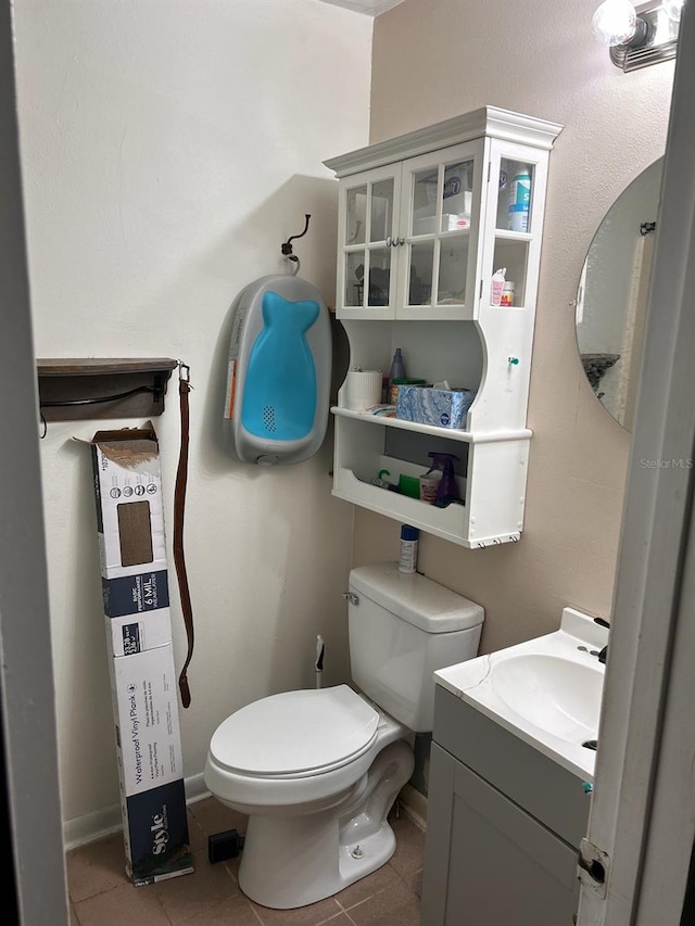 bathroom with tile flooring, vanity, and toilet