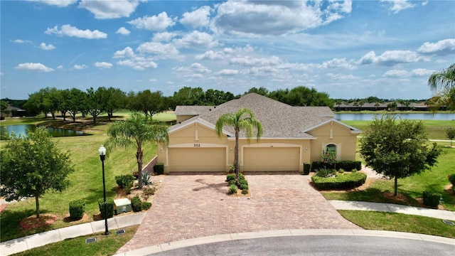 ranch-style house featuring a garage, a water view, and a front lawn