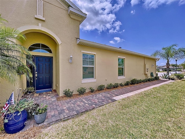 property entrance with a lawn