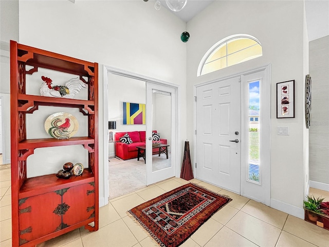 foyer entrance featuring high vaulted ceiling and tile flooring