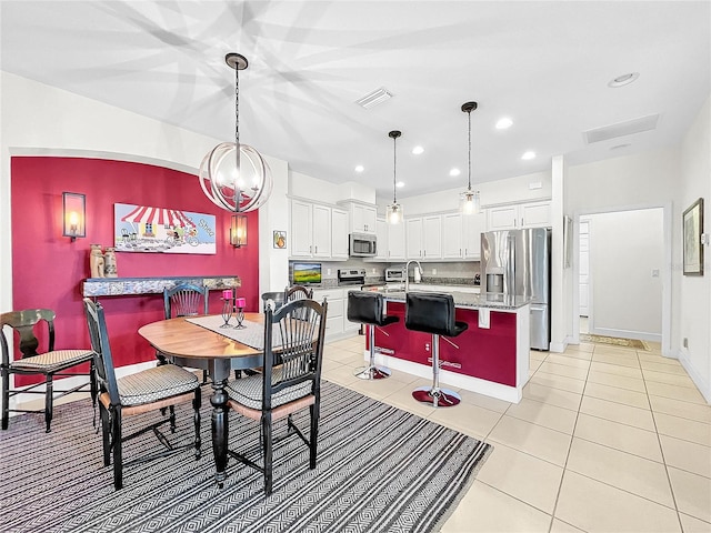 tiled dining area featuring a notable chandelier and sink