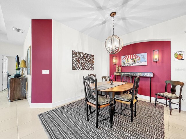 tiled dining space featuring an inviting chandelier