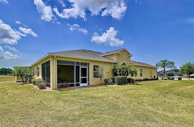 rear view of house with a yard and a sunroom