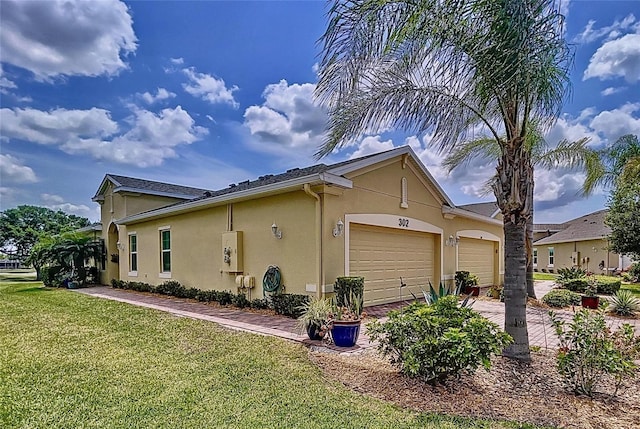 view of side of home featuring a garage and a lawn