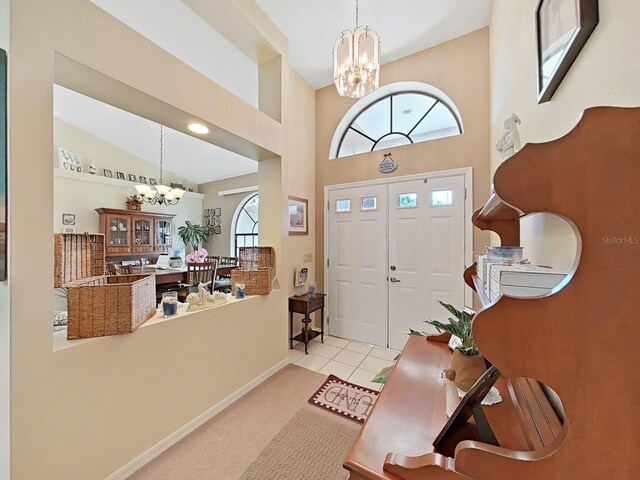 carpeted entrance foyer with a towering ceiling, an inviting chandelier, and a wealth of natural light