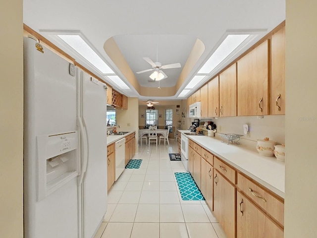 kitchen featuring ceiling fan, white appliances, light tile flooring, a raised ceiling, and sink