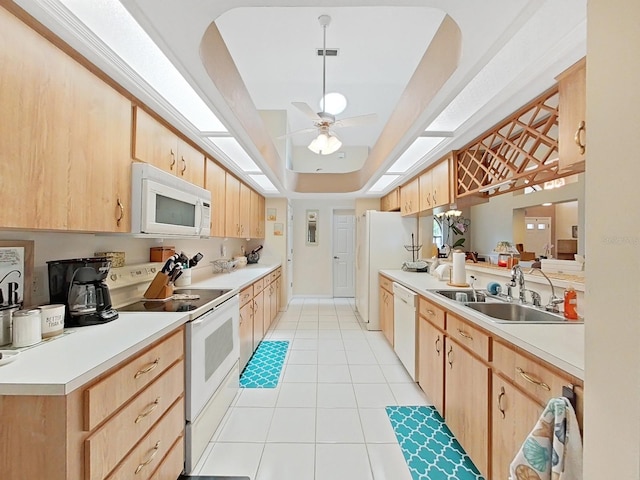 kitchen with ceiling fan, light brown cabinetry, white appliances, and a tray ceiling