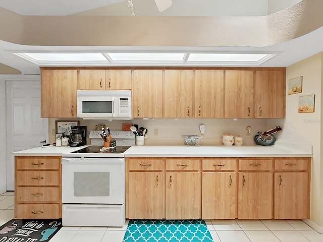 kitchen with light brown cabinetry, white appliances, and light tile flooring