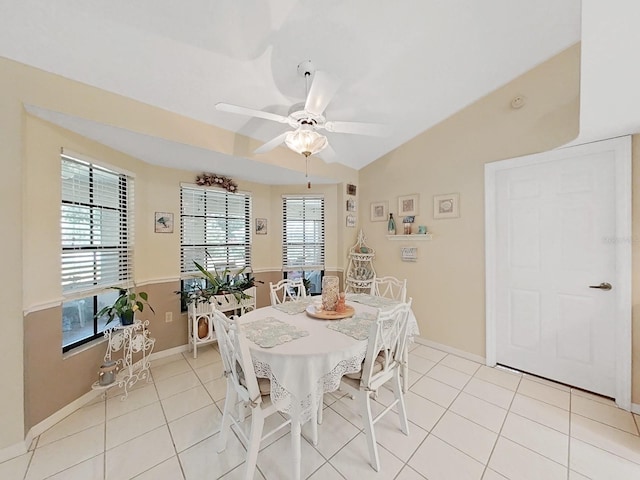 dining space featuring ceiling fan, vaulted ceiling, and light tile floors