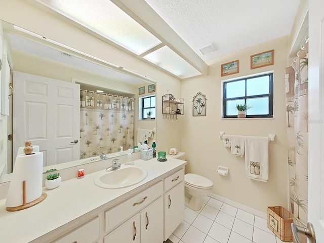 bathroom with tile flooring, large vanity, toilet, and a textured ceiling