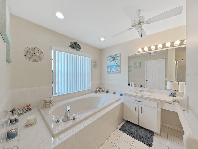 bathroom with a relaxing tiled bath, tile flooring, vanity, and ceiling fan