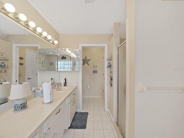 bathroom featuring tile floors, a shower with door, and vanity