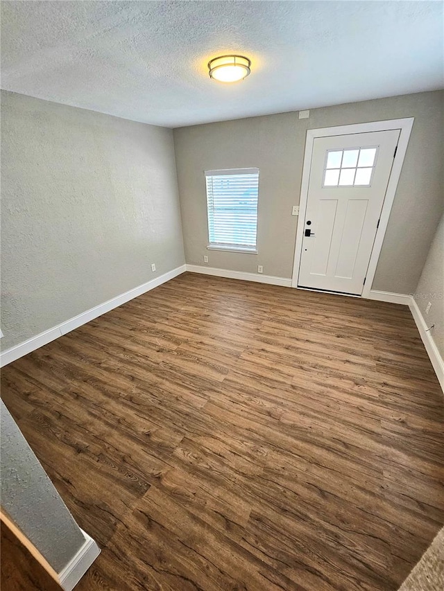 foyer with a textured ceiling and dark wood-type flooring