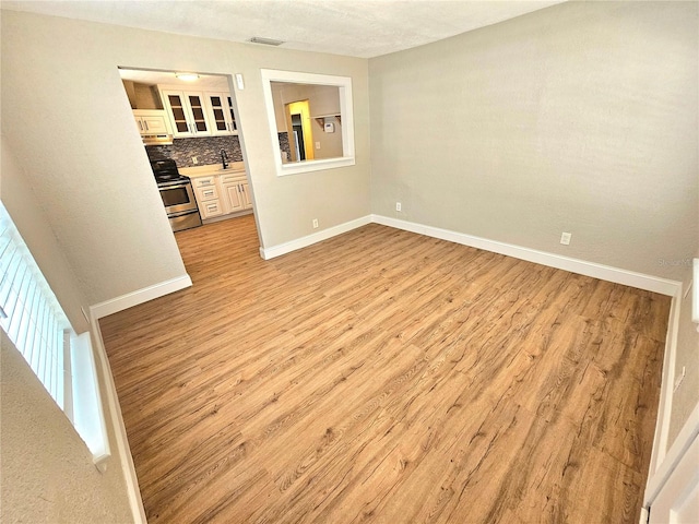 unfurnished bedroom featuring light hardwood / wood-style floors and sink