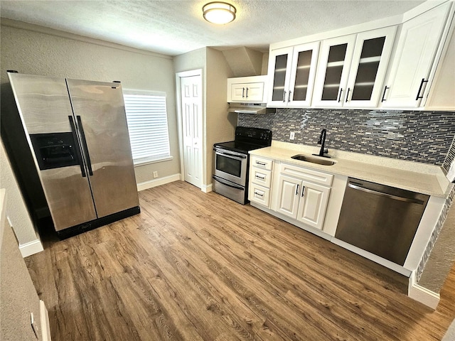 kitchen featuring white cabinets, appliances with stainless steel finishes, sink, and hardwood / wood-style flooring