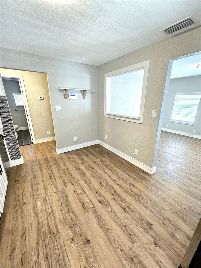 empty room featuring hardwood / wood-style flooring and a textured ceiling