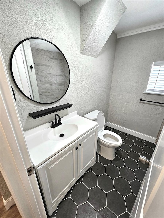 bathroom with tile flooring, ornamental molding, vanity, and toilet