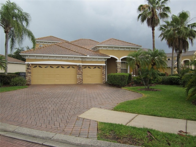 mediterranean / spanish-style home with a garage and a front lawn