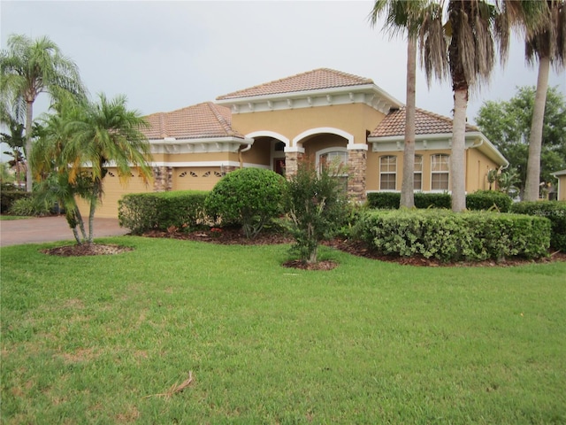 mediterranean / spanish home with a front lawn and a garage