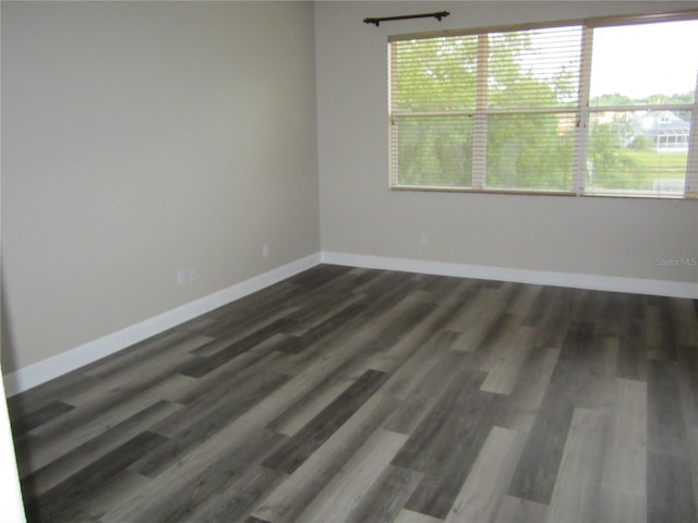 unfurnished room with a wealth of natural light and dark wood-type flooring