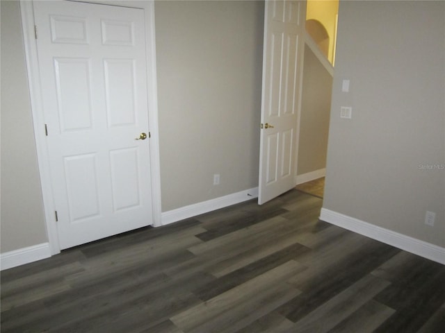 unfurnished bedroom with a closet and dark wood-type flooring