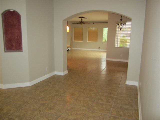 empty room featuring tile floors and a chandelier