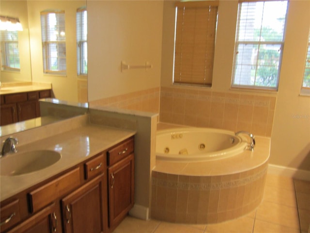 bathroom with tiled tub, vanity, and tile floors