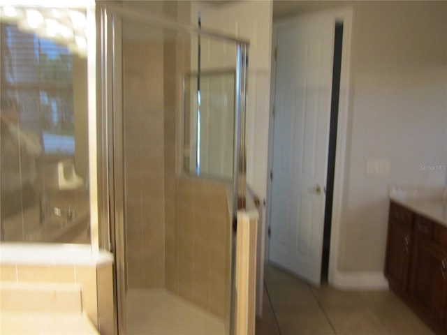 bathroom featuring a shower with shower door, tile flooring, and vanity