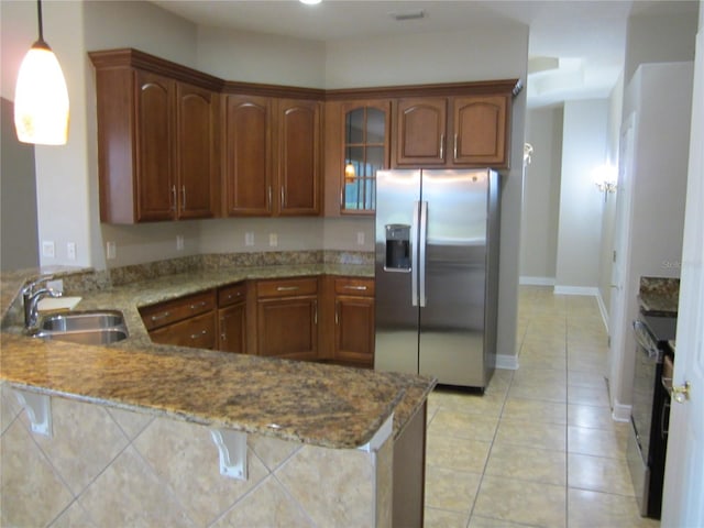 kitchen with kitchen peninsula, range with electric cooktop, stainless steel refrigerator with ice dispenser, pendant lighting, and light tile floors