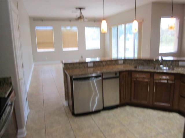 kitchen with a wealth of natural light, stainless steel dishwasher, and decorative light fixtures