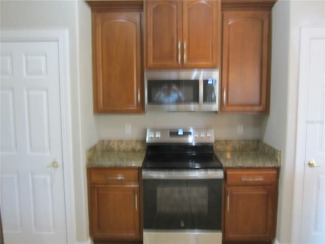 kitchen featuring stainless steel appliances and light stone counters