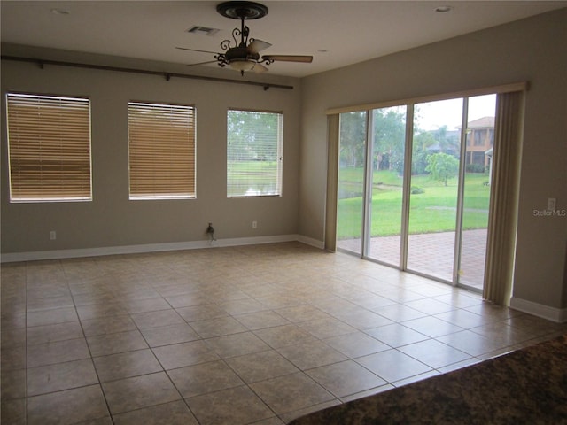 tiled spare room featuring ceiling fan