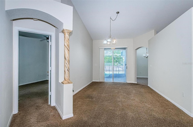 spare room with a notable chandelier, dark colored carpet, ornate columns, and vaulted ceiling