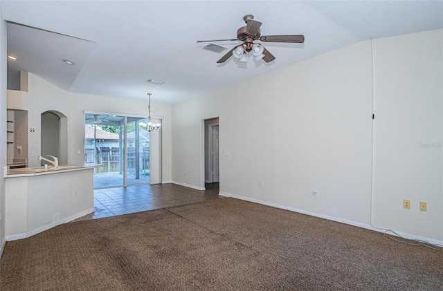 carpeted spare room featuring vaulted ceiling and ceiling fan with notable chandelier